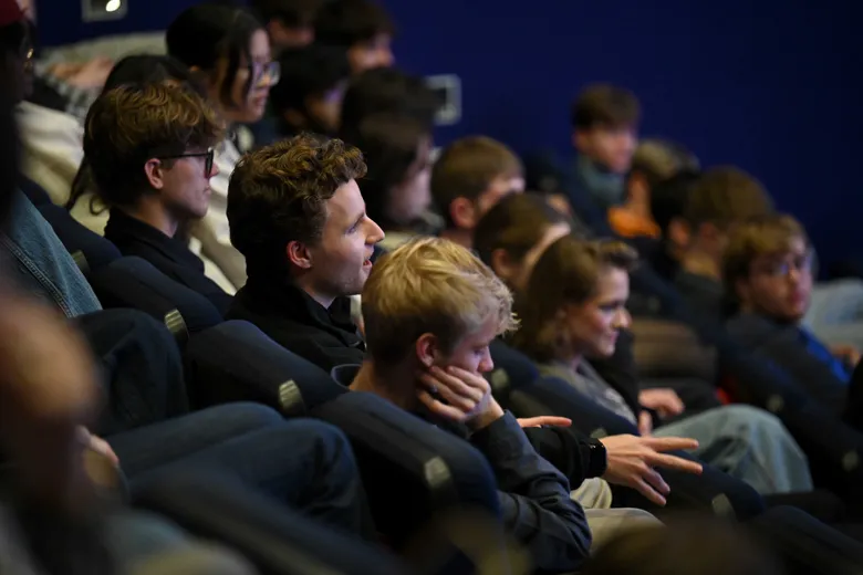 Young adults sitting in a tiered lecture theatre