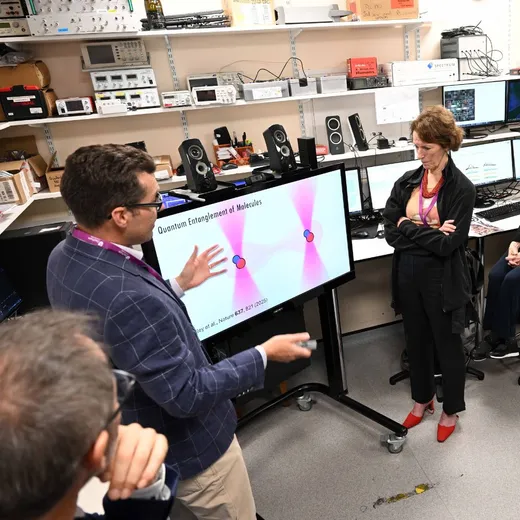 A man and woman in a science lab, speaking while looking at a screen