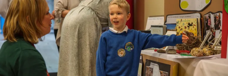 A schoolboy points to a wildlife display