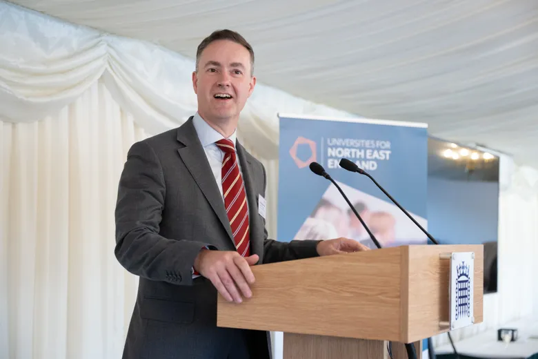 Man in suit and tie standing at lectern