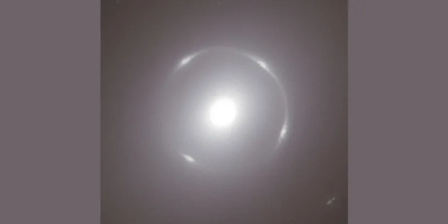 A close-up view of the centre of the bright, circular NGC 6505 galaxy, with the bright white Einstein Ring around its nucleus.