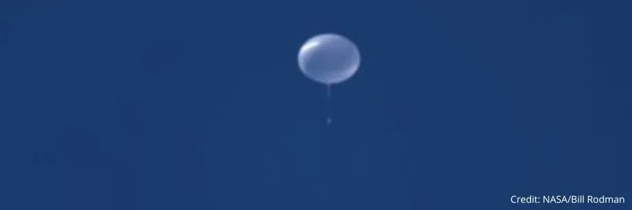A white giant helium balloon against a dark blue sky