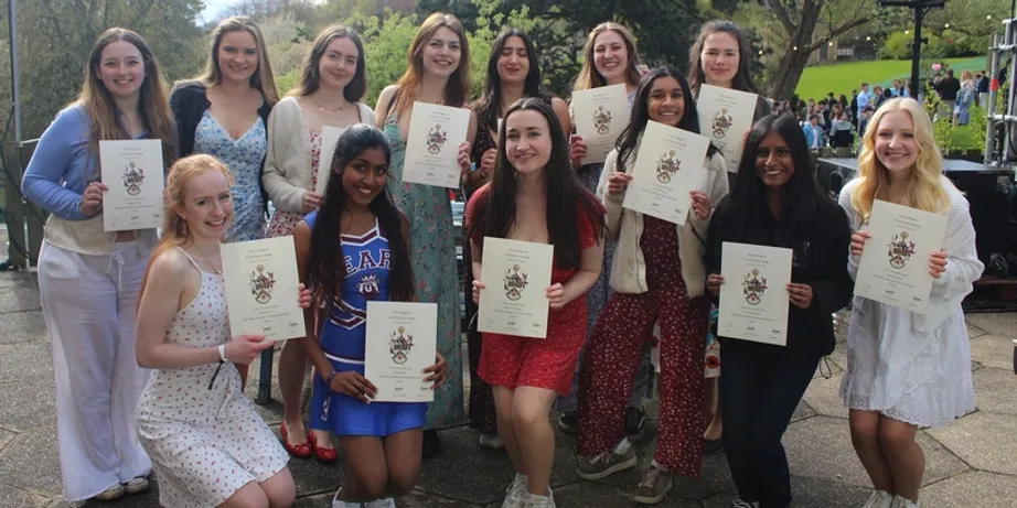 A small group of students sighed up facing the camera showing award certificates they have received