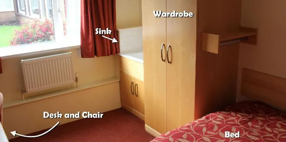 Student bedroom with a single bed, wardrobe and sink