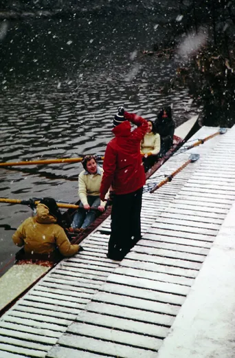students board a boat in the snow