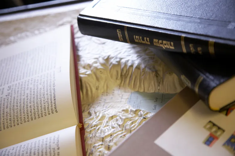 Close-up of books resting on 3D map