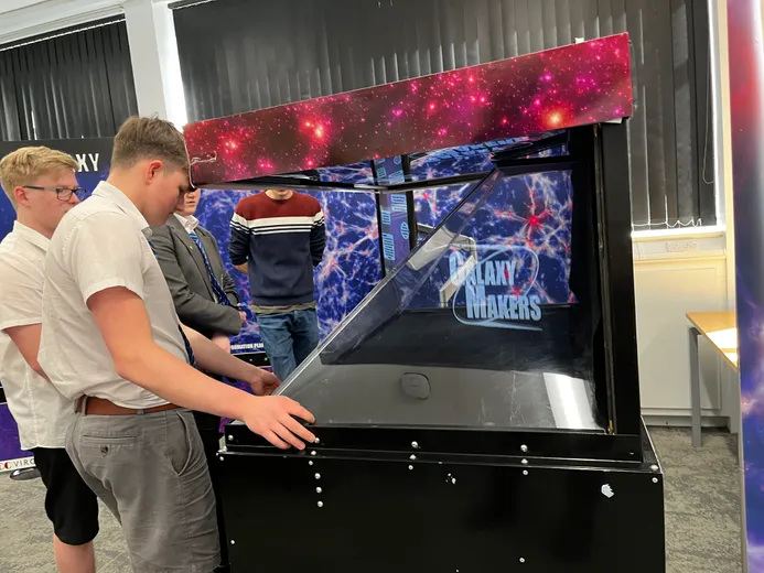 Two teenage students with 2 adults taking part in astronomy experiment