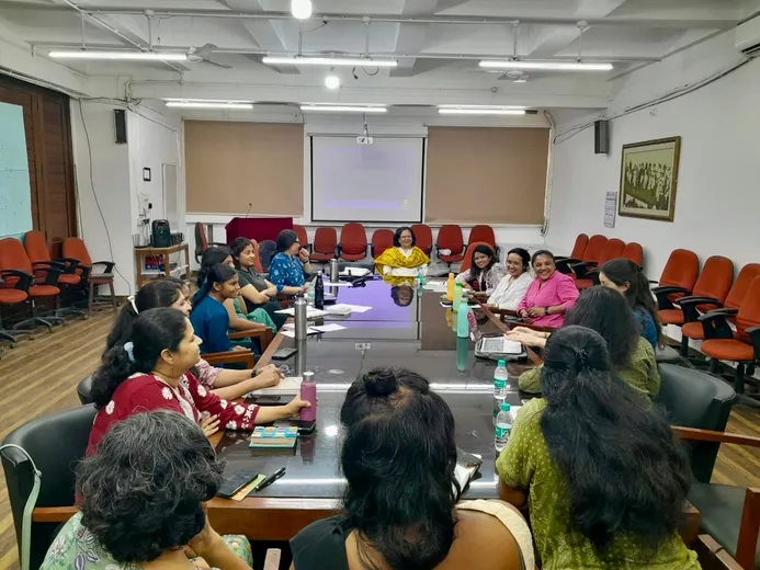 Colleagues sat around large table in discussion