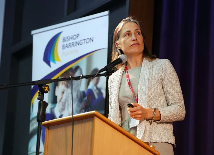 Dr Fiona Hill standing at a podium talking into a microphone