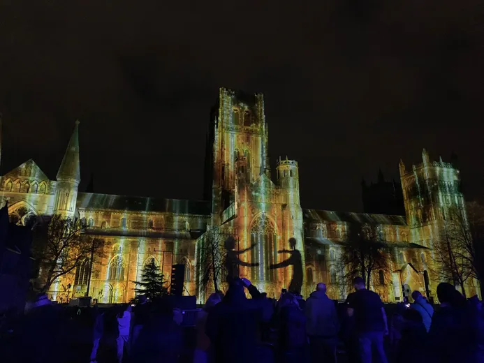 Durham Cathedral illuminated during the Lumiere festival with crowds in the foreground