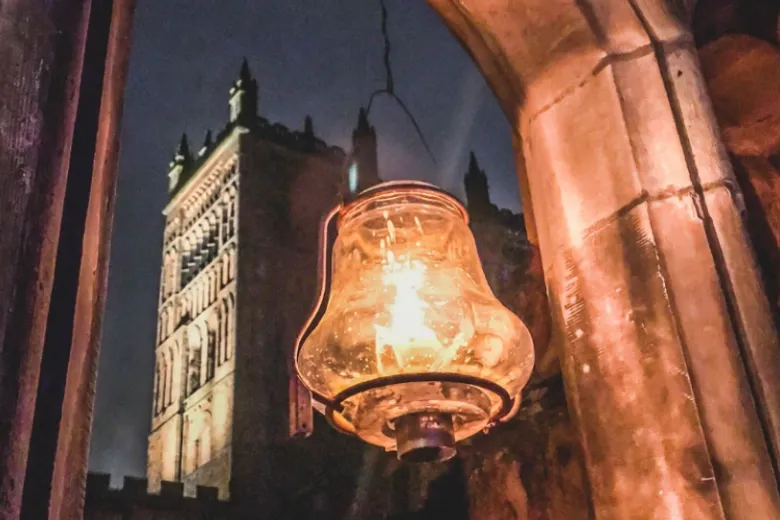 A lantern illuminated in the foreground with a view of Durham Cathedral behind