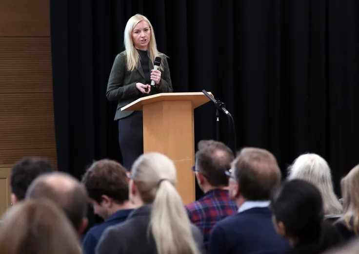 A woman talking in front of an audience