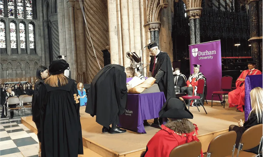 Student signing the Matriculation Book on stage