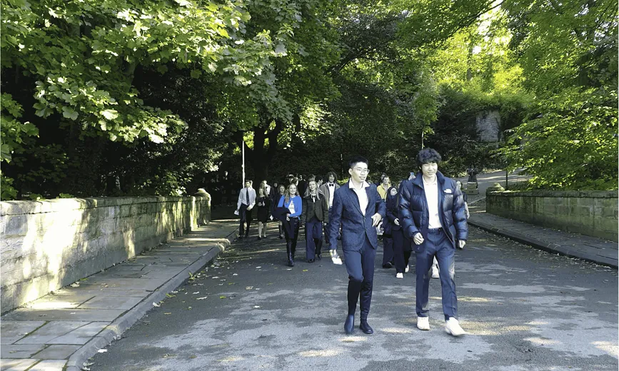 A group of students walking on a tree lined street