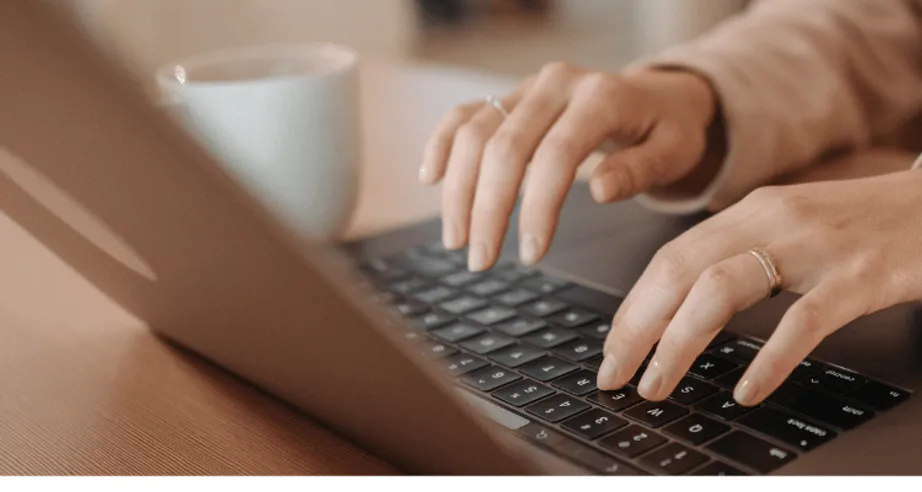Fingers typing on a laptop