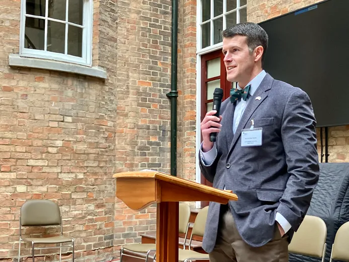 A man in a suit at a lectern with a microphone