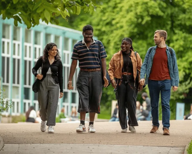 Four students walking through the campus