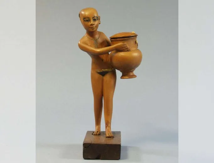Carving of a servant girl carrying a cosmetics jar dating to the 18th dynasty