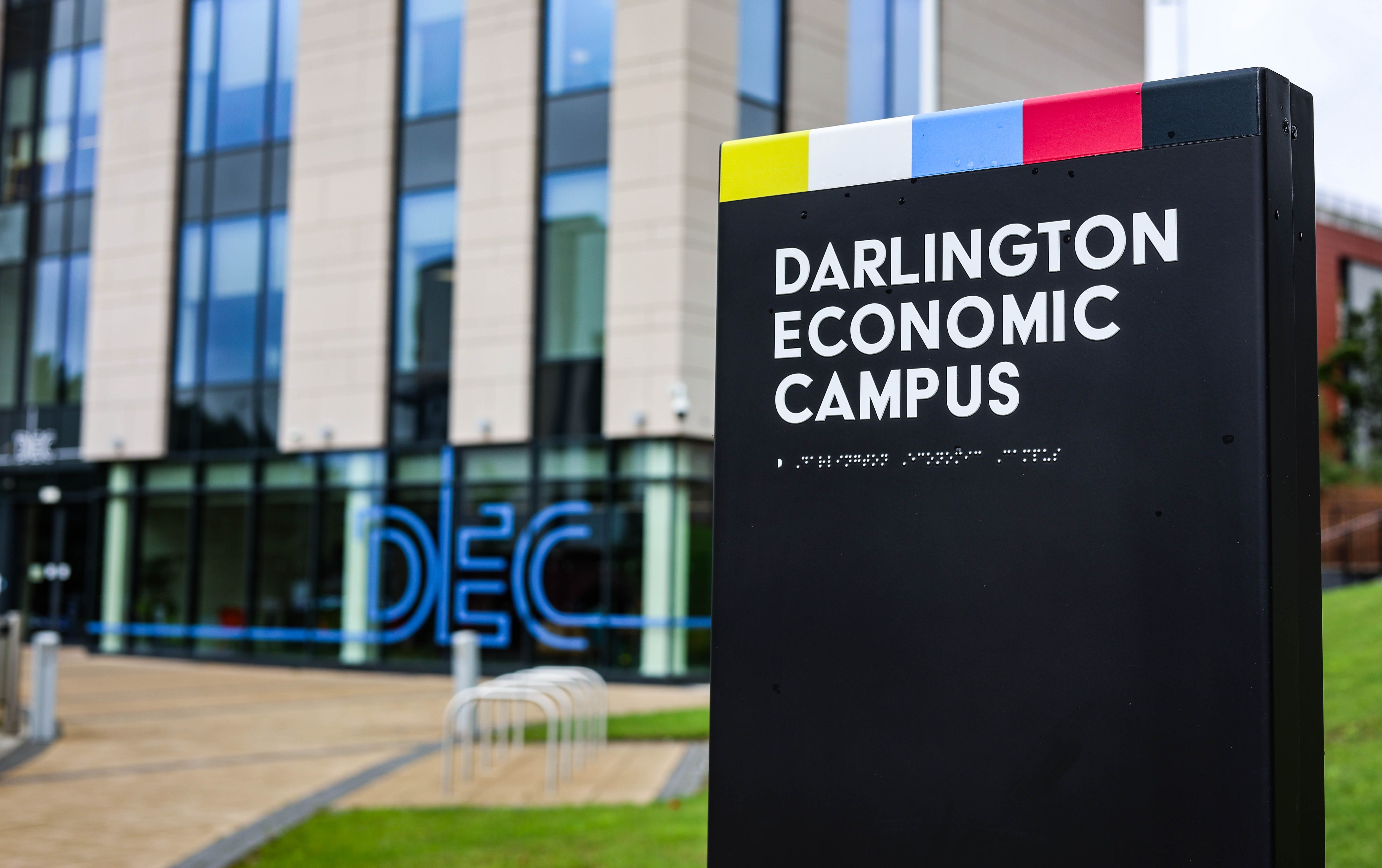 Outside Darlington Economic Campus in front of the building with a sign in the foreground