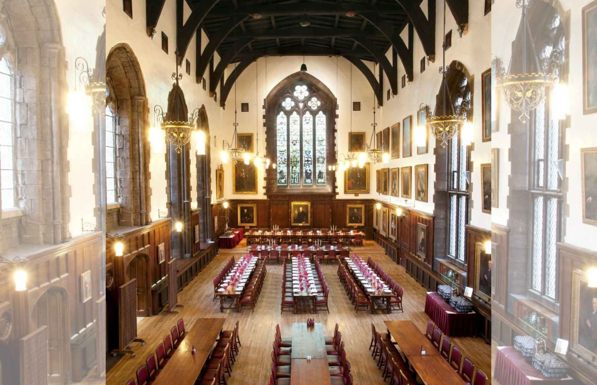 The Great Hall of Durham Castle, looking north towards the 19th-century-stained glass window. Tables are laid out in rows at the front of the picture.