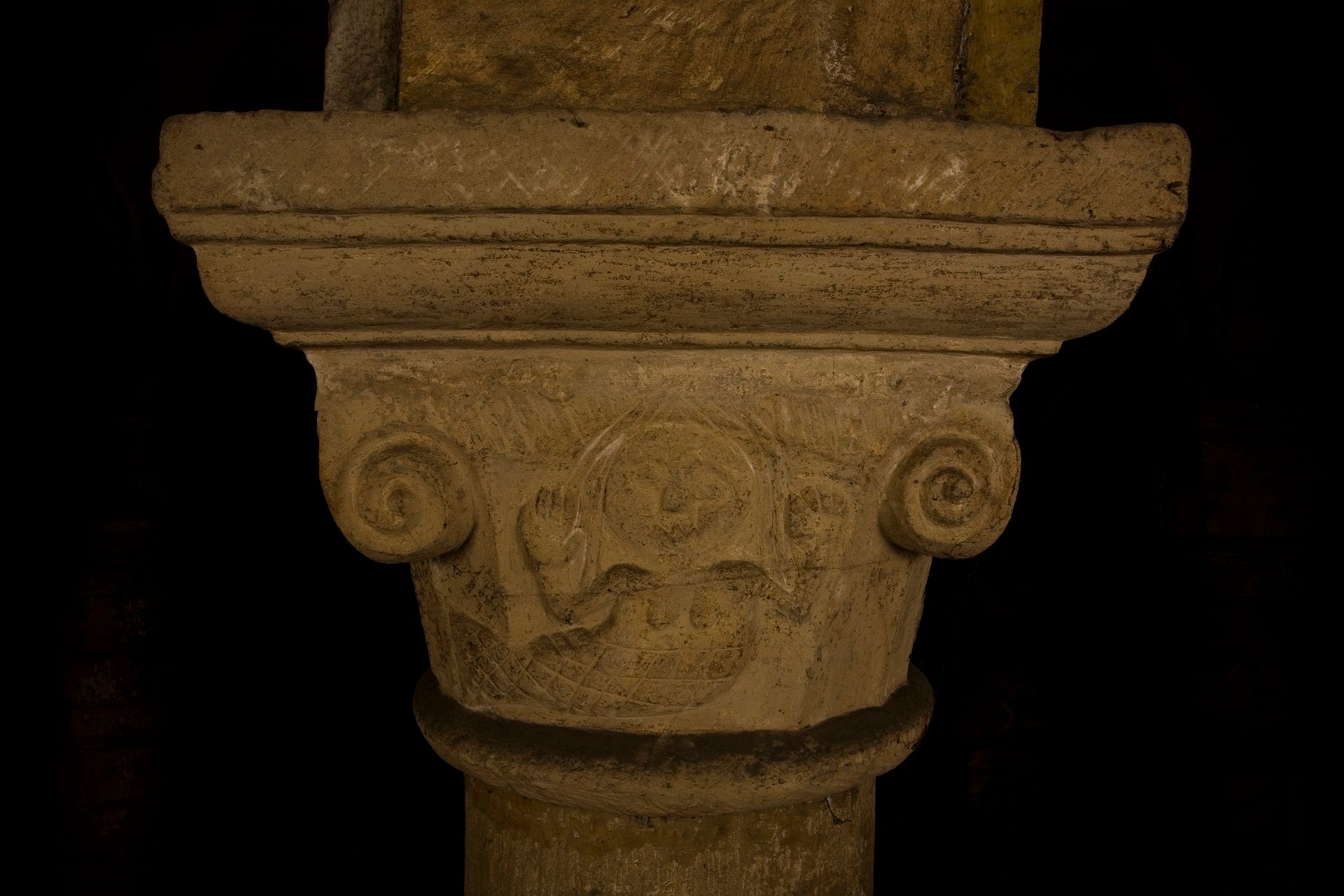 A coloured photograph of the mermaid in the Norman Chapel. She is depicted with long hair, a tail and with her hands held up.