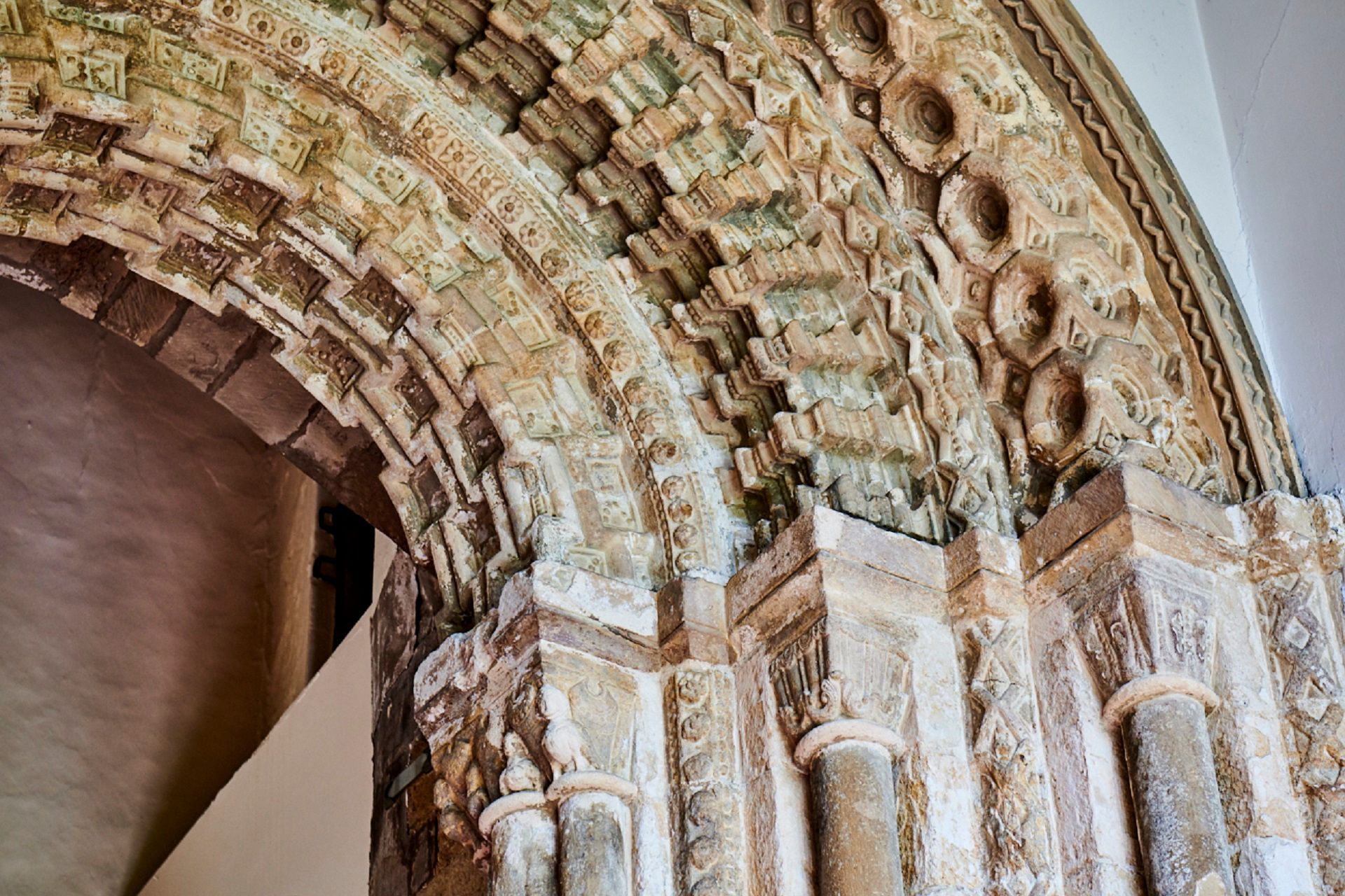 Close-up photograph of the detail on the Norman Arch at Durham Castle, with geometric and concentric decoration and detail.