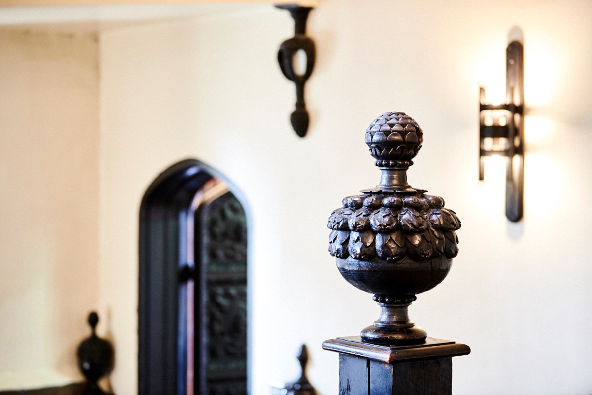 Photograph of the pineapples on the Black Stairs at Durham Castle. On the right is a door and on the left is a carving with is meant to represent a pineapple.