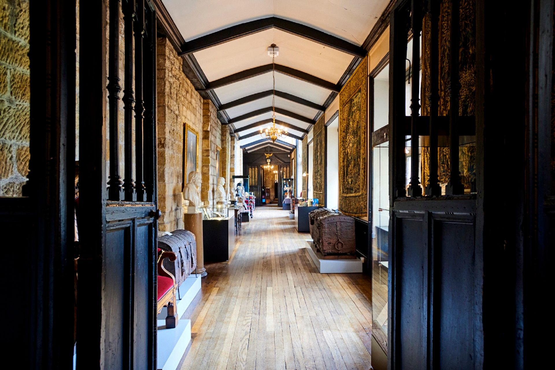 Looking down the Tunstall Gallery in Durham Castle, featuring wooden panelling and the museum displays.