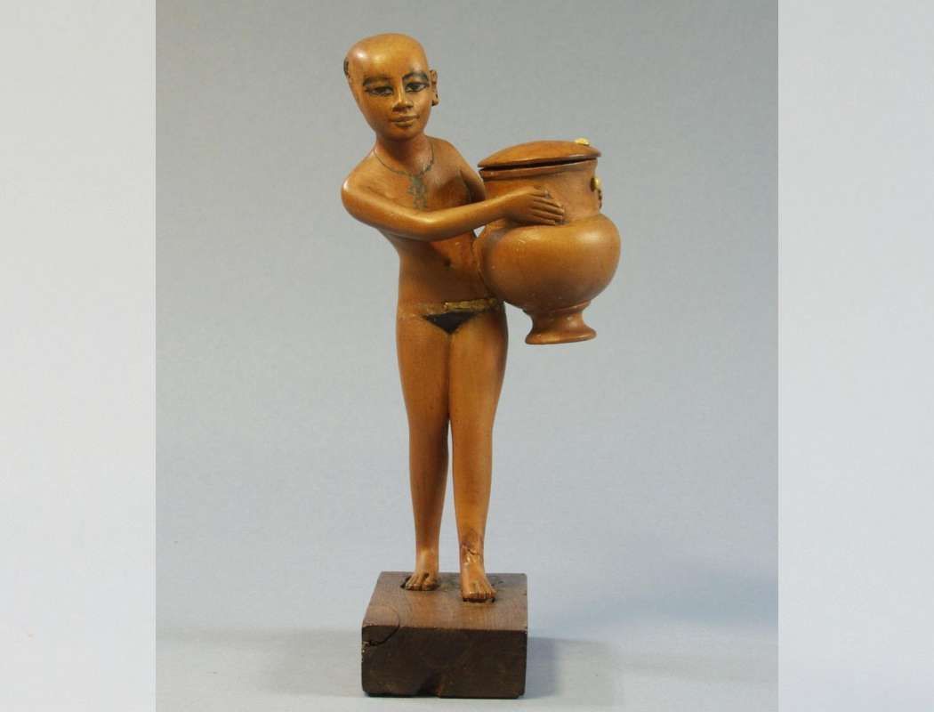 Carving of a servant girl carrying a cosmetics jar dating to the 18th dynasty