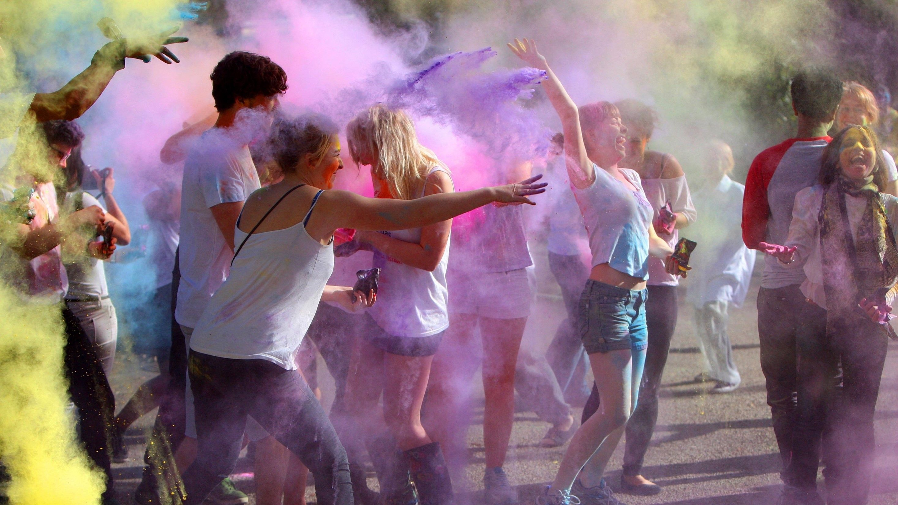 Students taking part in the Indian tradition of throwing coloured powder over each other during Holi Festival