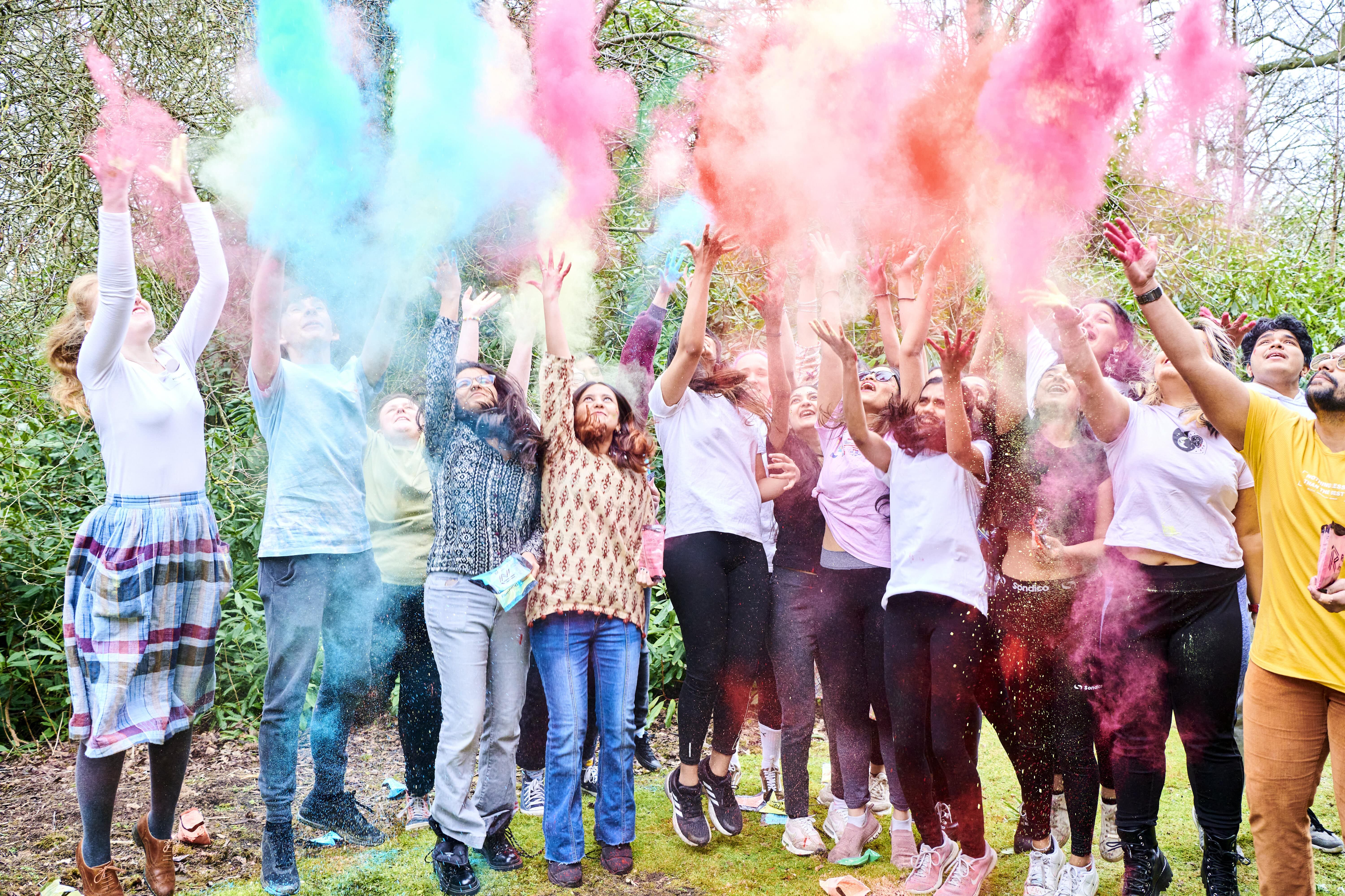 Students throwing coloured powder at Durham Global Week Holi Festival