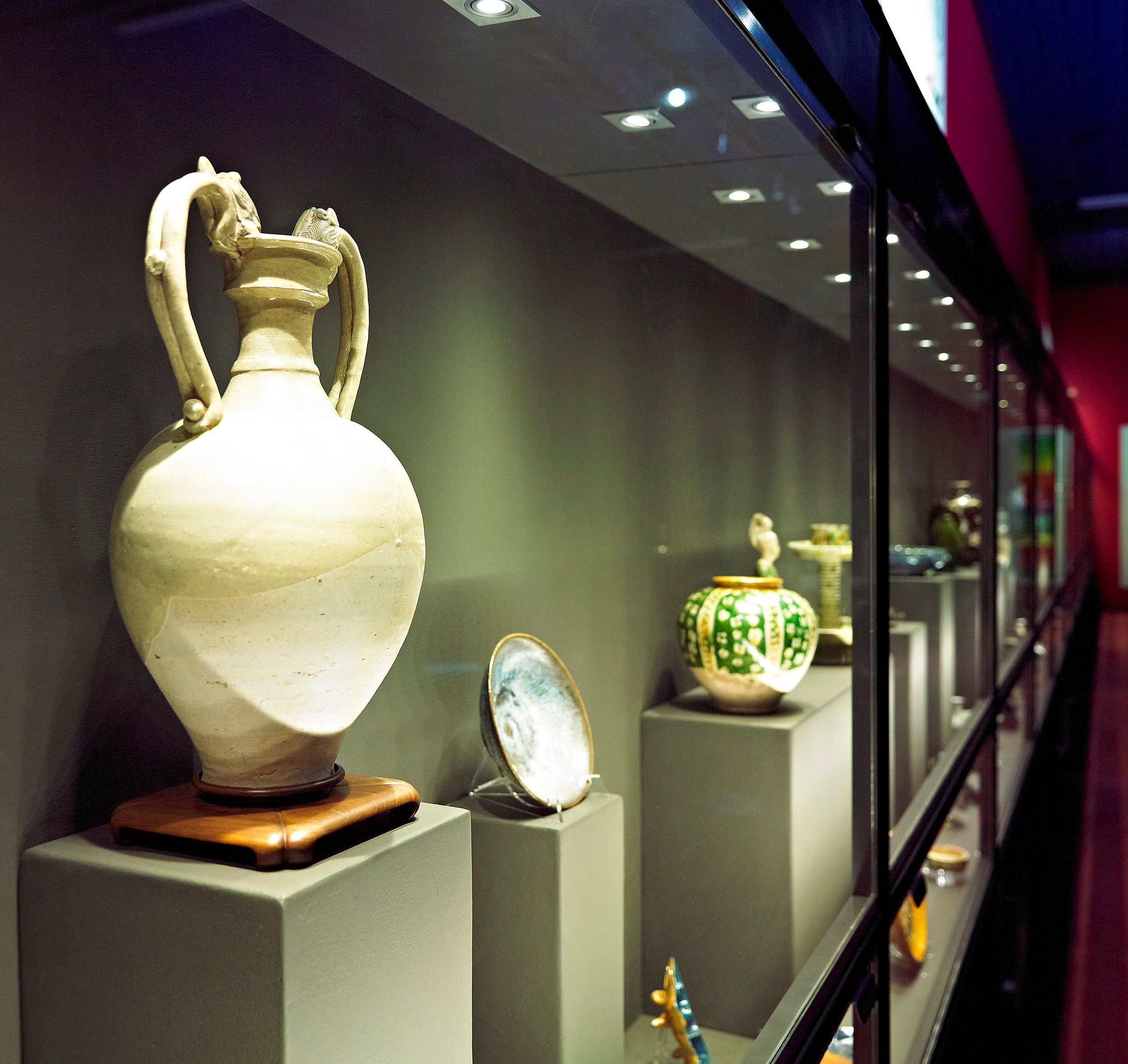 Various items of pottery on display in a glass cabinet