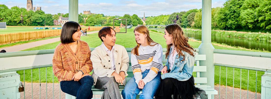 A group of students chatting on a bench