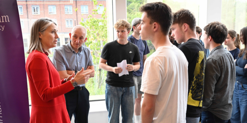 Chancellor Dr Fiona Hill talking to Gosforth Academy students and teacher Keith Wood