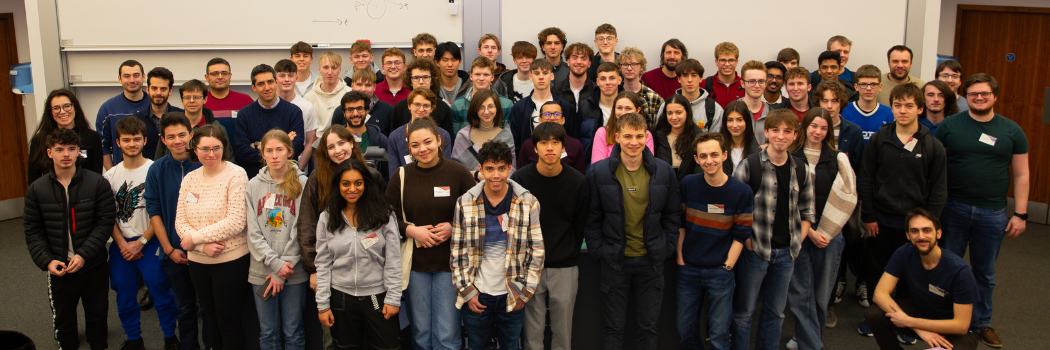 A group of smiling pupils in a lecture theatre