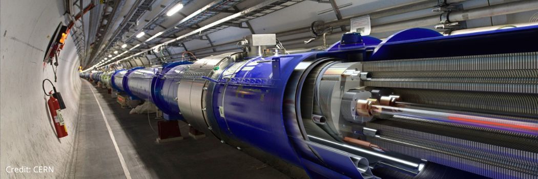 A high-tech silver and blue metal tube extends through an underground concrete tunnel.