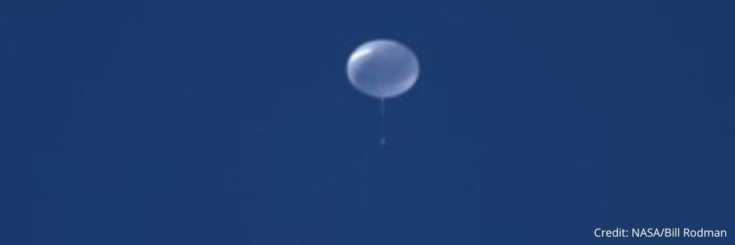 A white giant helium balloon against a dark blue sky