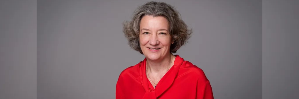 The Vice-Chancellor Prof Karen O'Brien smiling at the camera wearing a red top