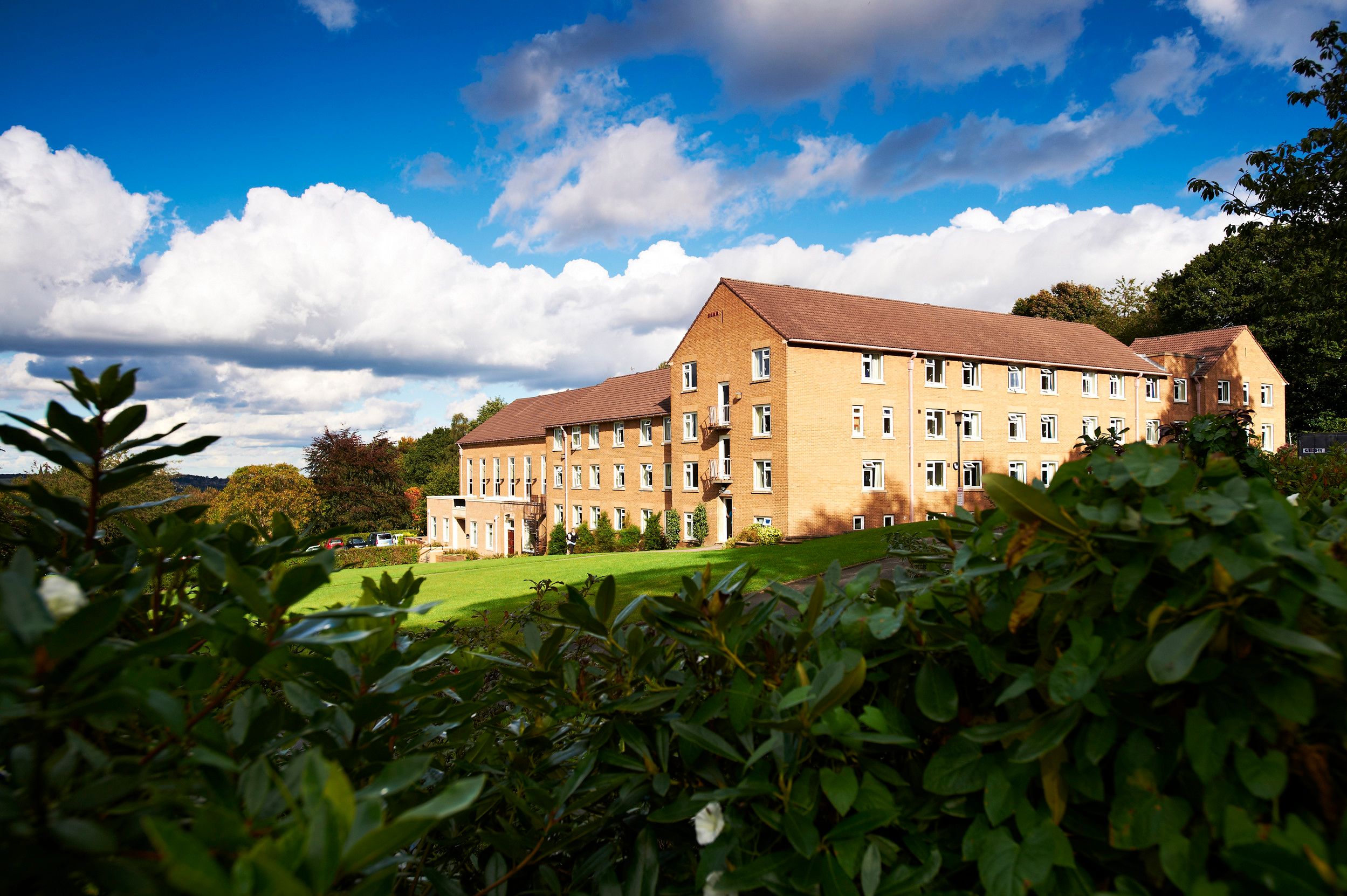 View of Grey College from a distance surrounded by trees and plants