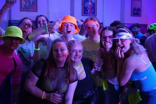 A group of students with neon facepaint and glowsticks at the Neon Bop