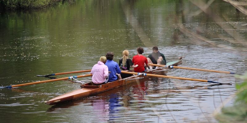 Five people in a rowing boat on the river Wear