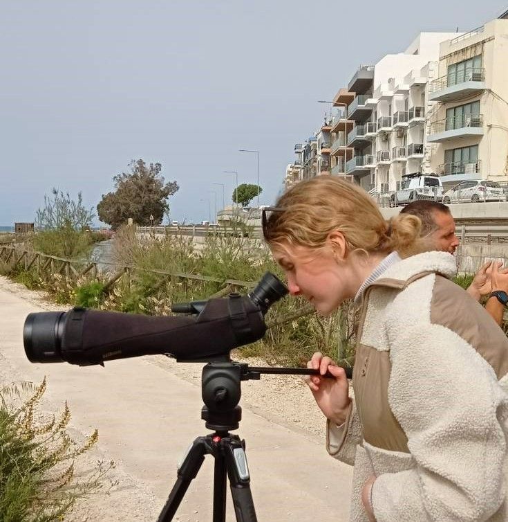 a female looking through a telescope