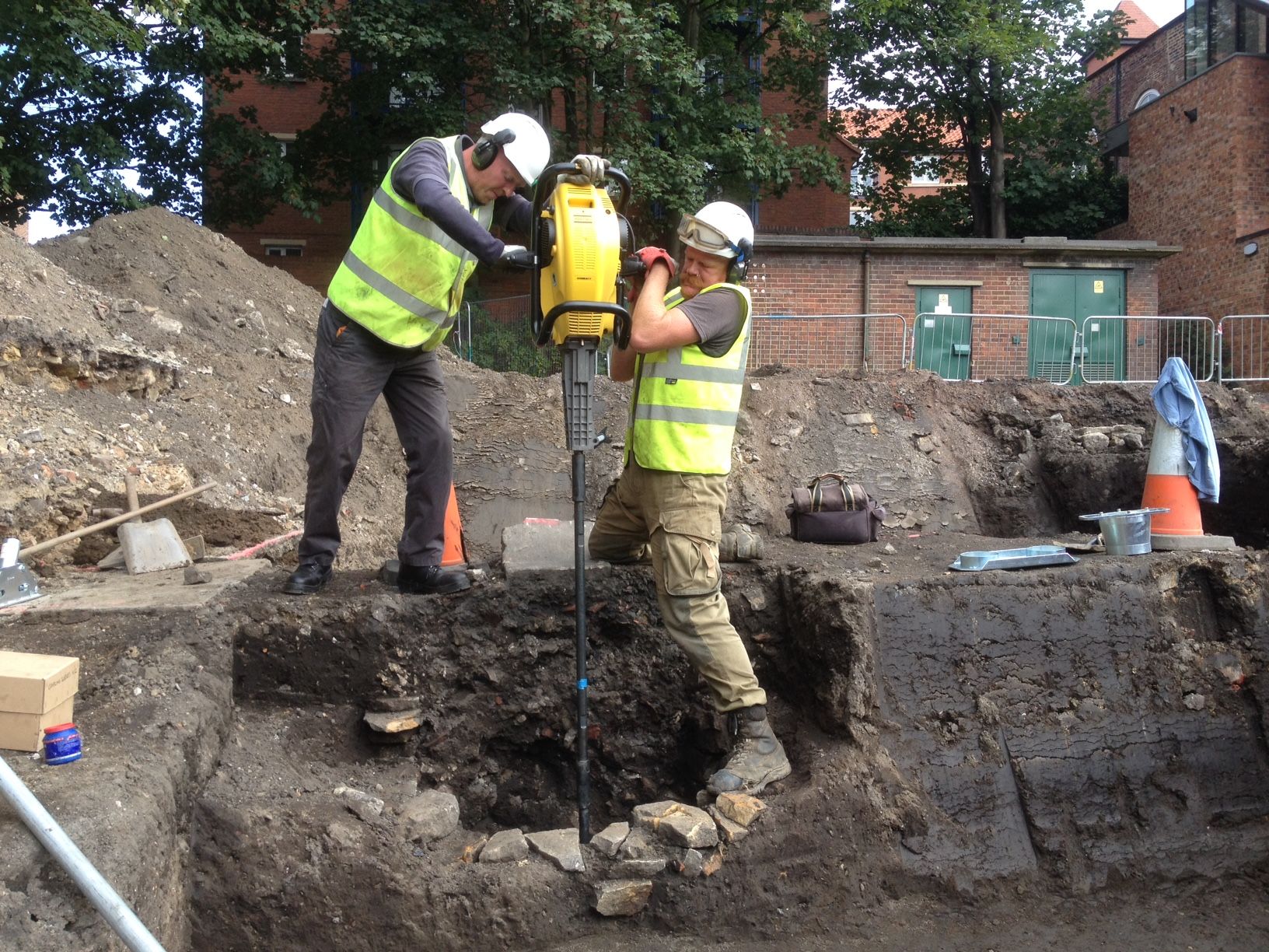 Two archaeologists using a handheld concussion borer to drill for palaeoenvironmental cores
