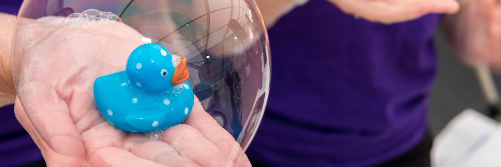 Celebrate Science festival volunteers holding rubber ducks in bubbles