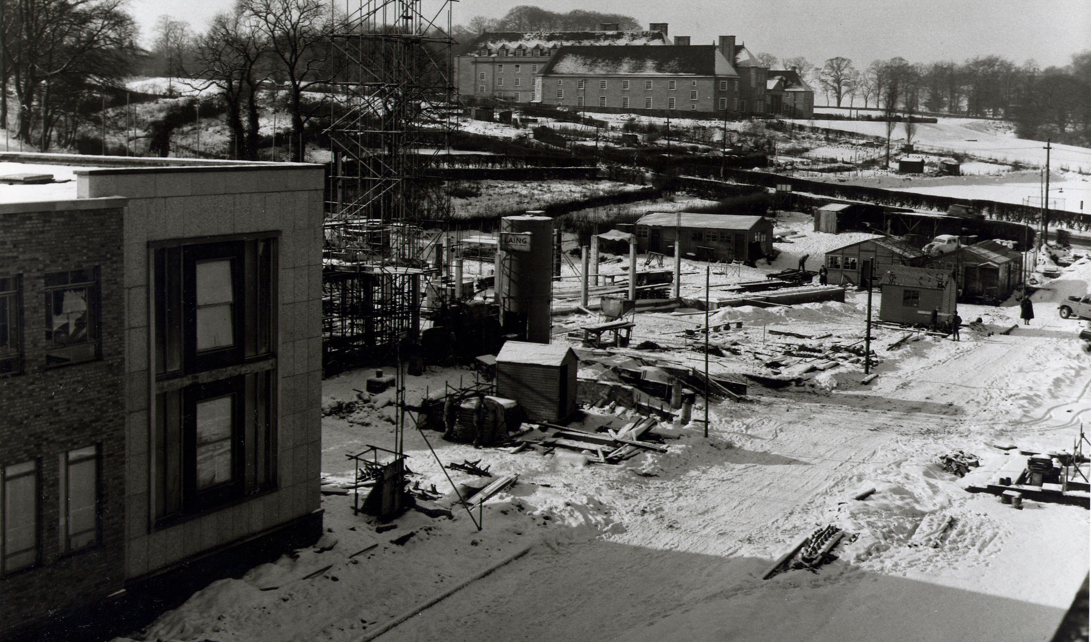 Image taken in the winter of 1959, with snow on the ground, of the construction of the Rochester Building. The Woodside end is shown complete, with the foundations being laid for the rest of the building.