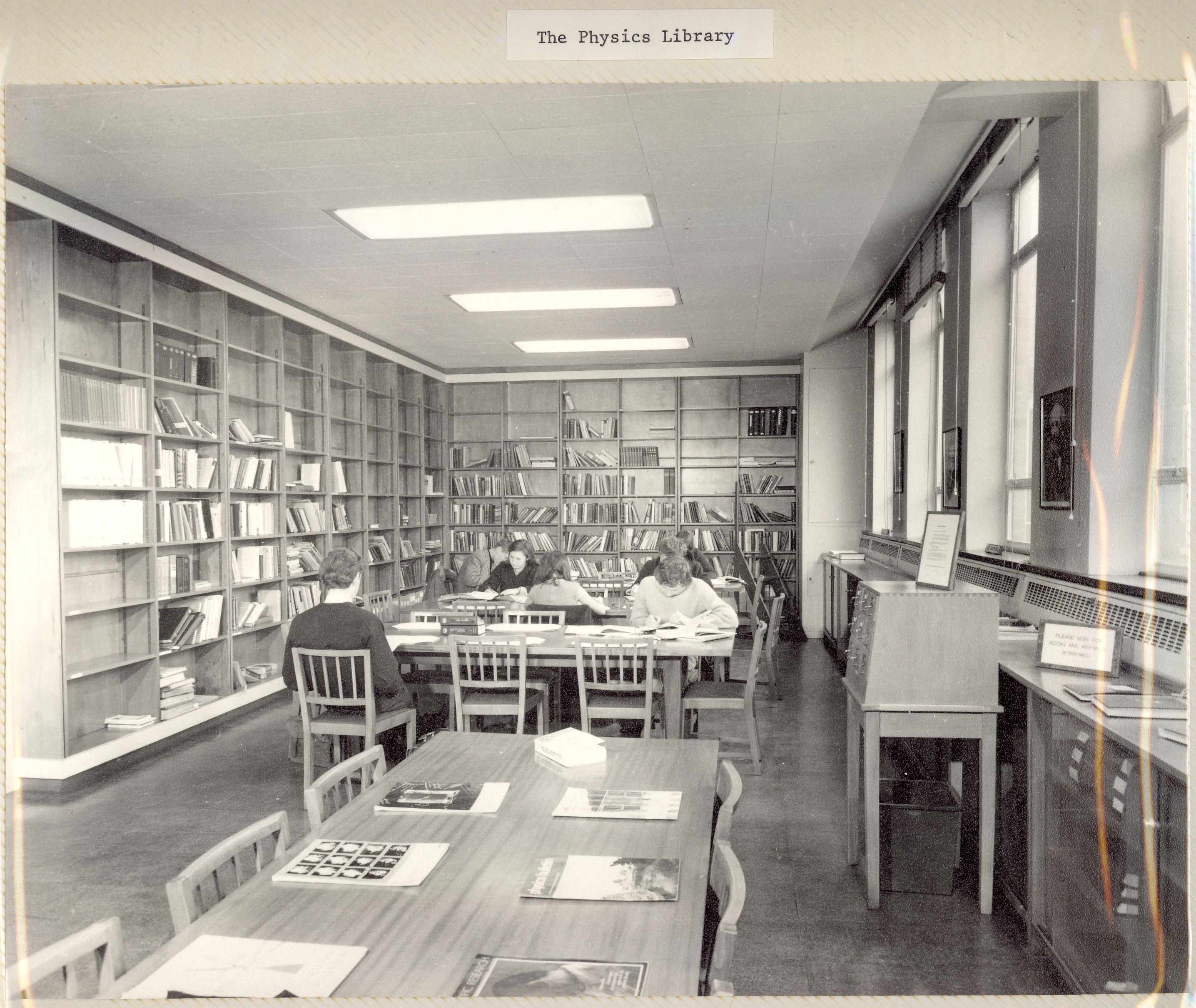 A student sat at a desk surrounded by mostly empty shelves