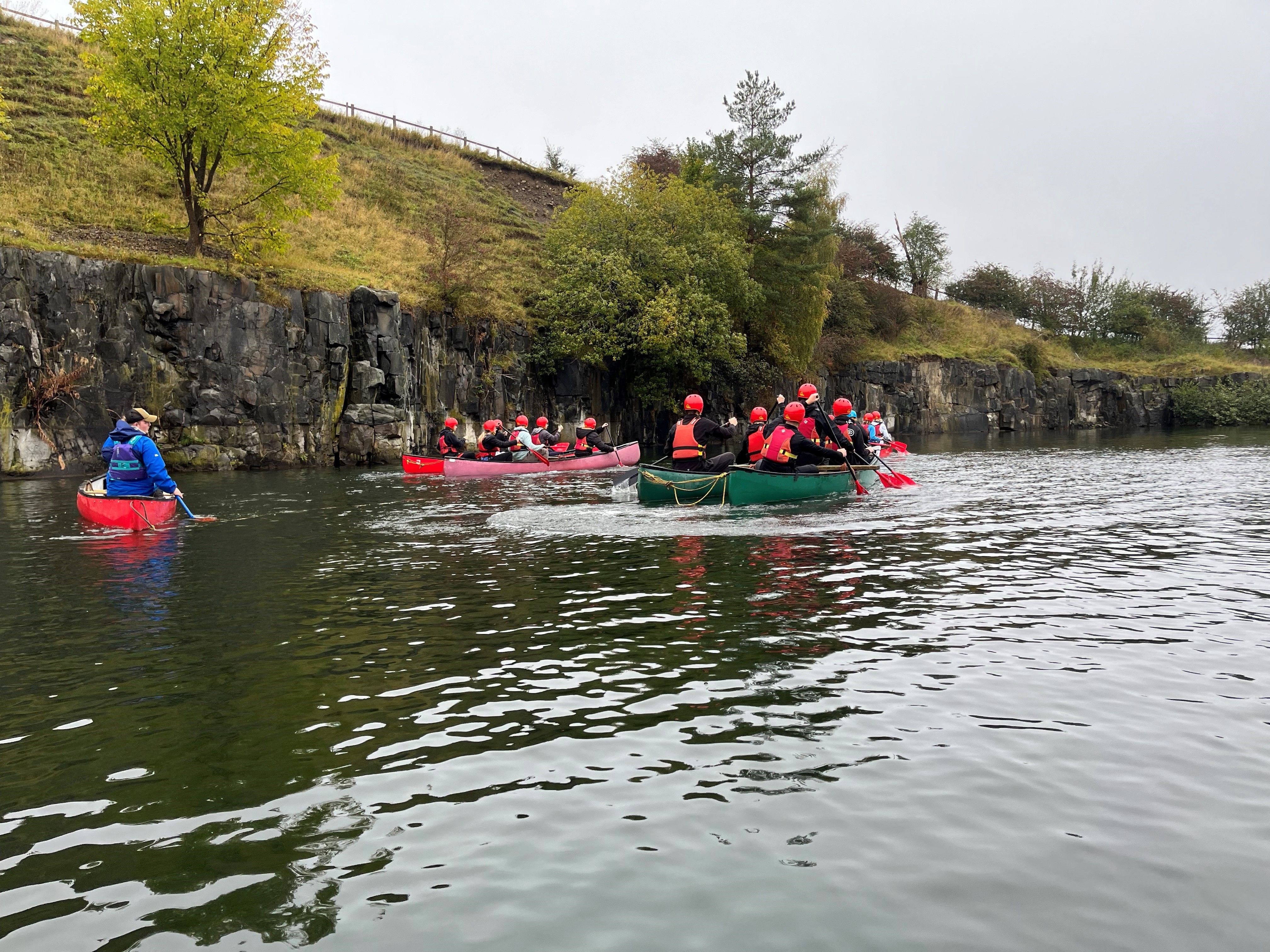 Students participating in a canoe race on a river.