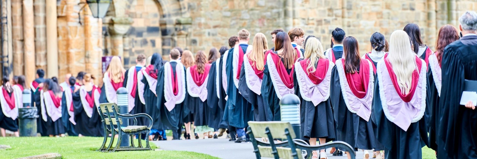 Graduands in robes and hoods processing into Durham Cathedral