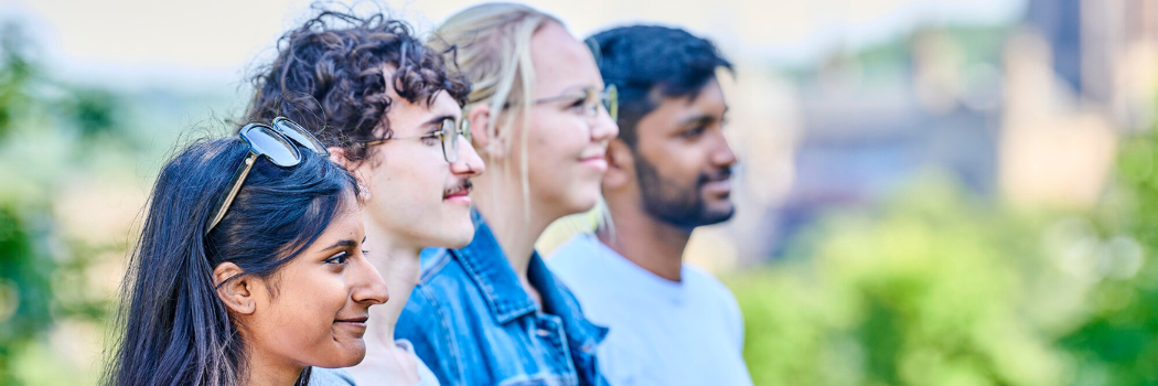 Four students pictured standing in a line