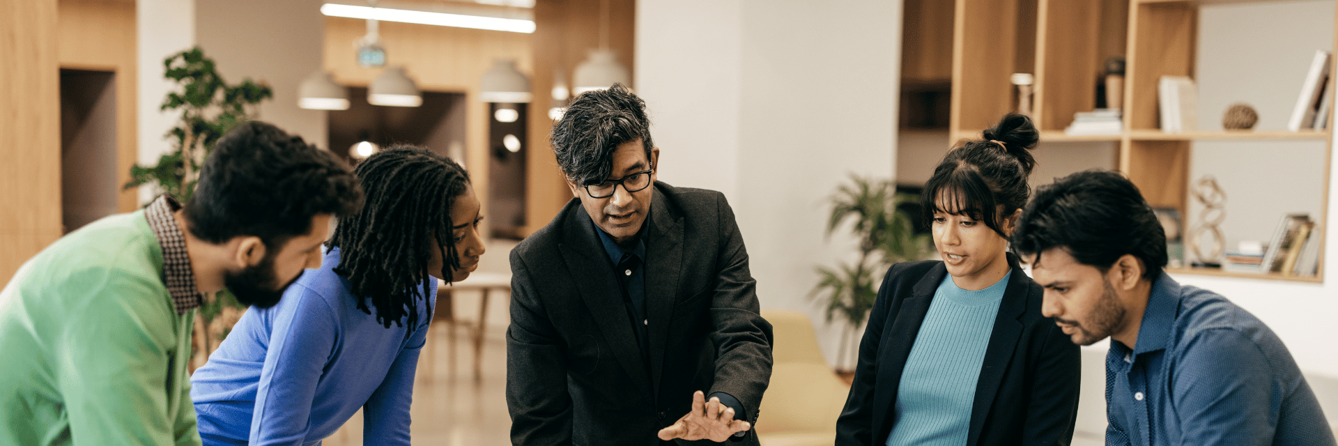 A group of business people standing around a table looking at a project